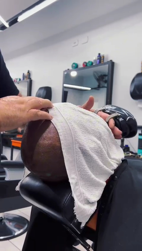 Barbeiro finalizando um atendimento com toalha na Barbearia Street Cut
