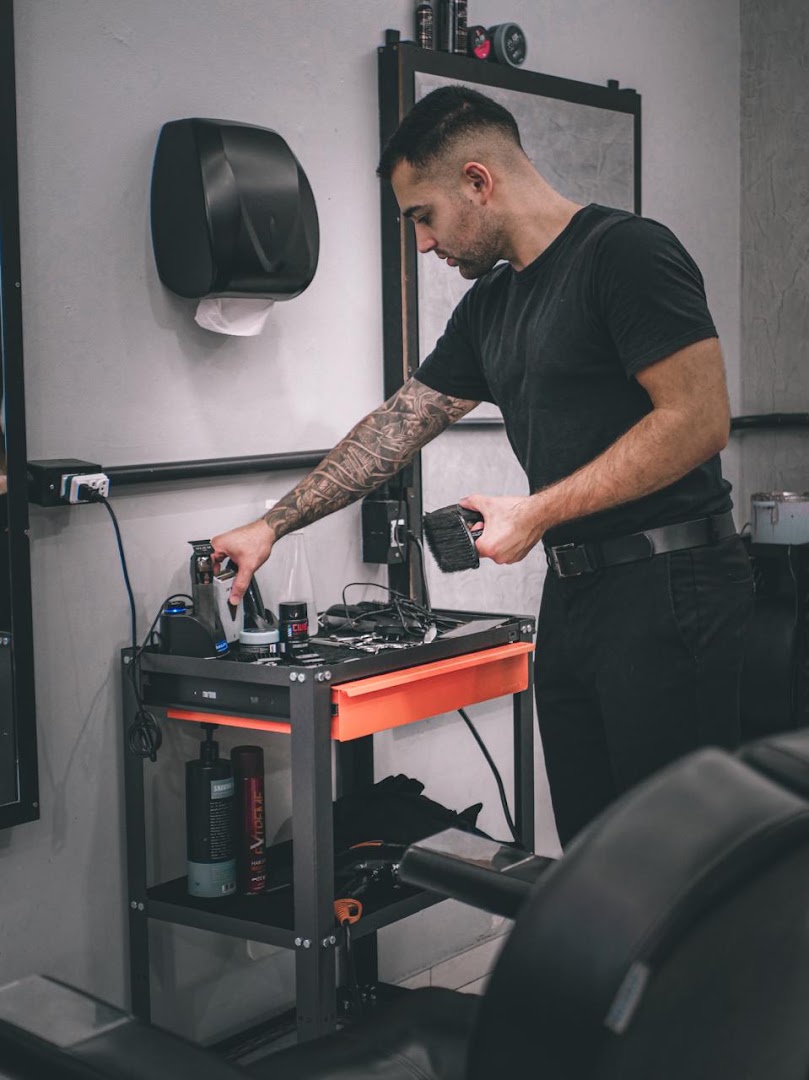 Barbeiro organizando os produtos na estação de trabalho da Barbearia Street Cut